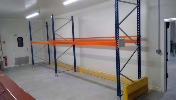 Racks lourds bleu et orange avec protections jaunes, à Hennebont