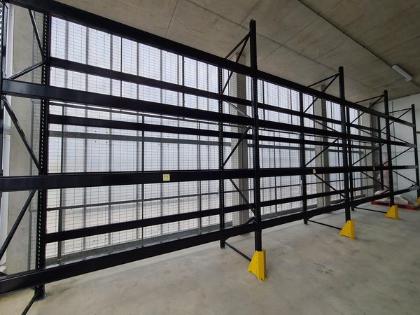Rack à palettes noir avec grille de protection, chez un traiteur à Poitiers